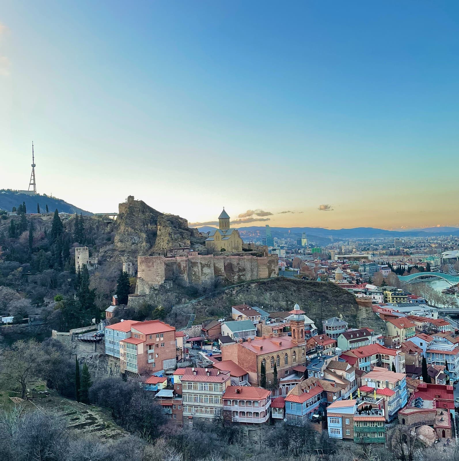 Tbilisinin Köhnə şəhəri günbatımında, təpədə Narikala qalası və dağ evləri